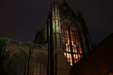 900627 Gezicht op het verlichte venster in de zuidertransept van de Domkerk (Domplein) te Utrecht.